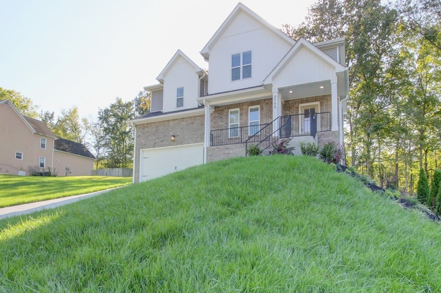 view of front of house featuring a front yard, a garage, and a porch