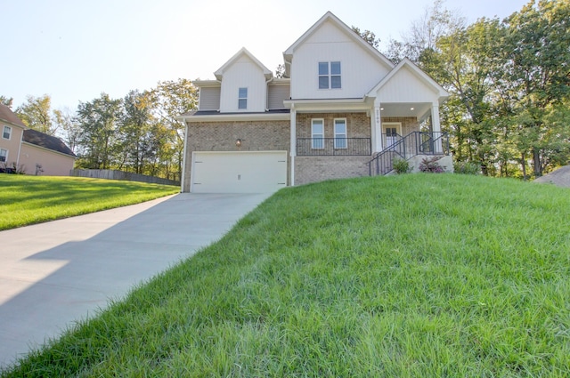 view of front of property with a garage, a front lawn, and covered porch