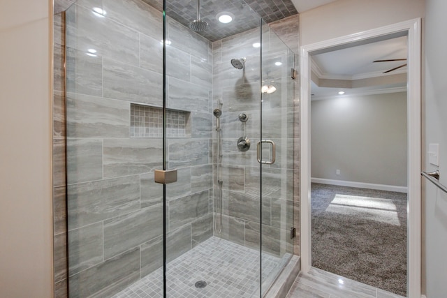 bathroom with ceiling fan, walk in shower, and crown molding