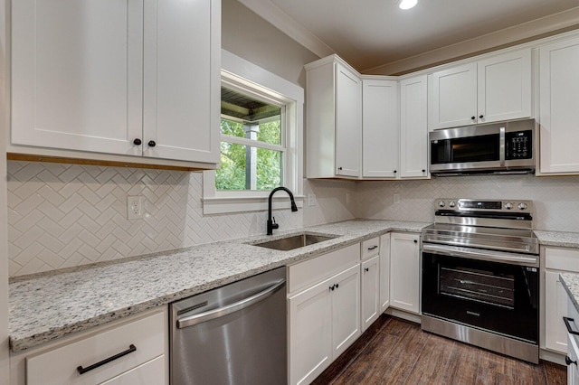 kitchen featuring a sink, tasteful backsplash, stainless steel appliances, and white cabinets