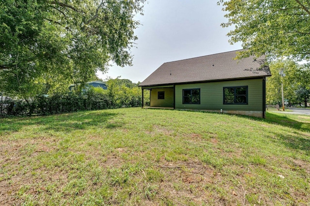 rear view of property featuring a lawn