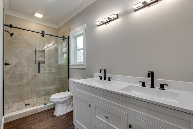 bathroom featuring a shower with shower door, vanity, hardwood / wood-style flooring, ornamental molding, and toilet