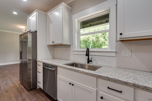 kitchen with decorative backsplash, dark wood-style floors, white cabinetry, a sink, and stainless steel appliances