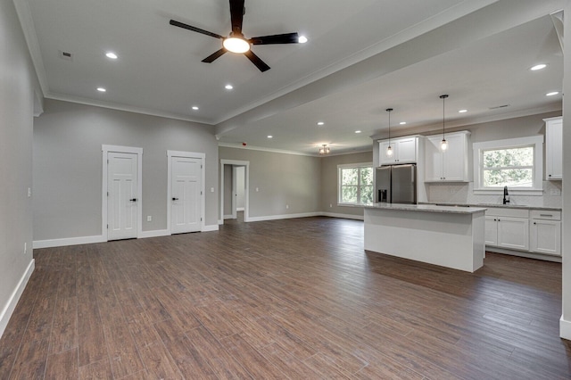 kitchen with stainless steel fridge, a kitchen island, dark wood-type flooring, and decorative light fixtures