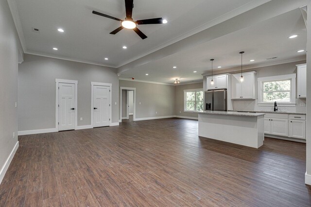 kitchen featuring stainless steel fridge, crown molding, and a sink