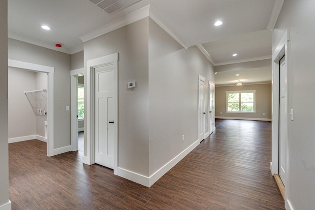 hallway with crown molding, baseboards, and dark wood-type flooring