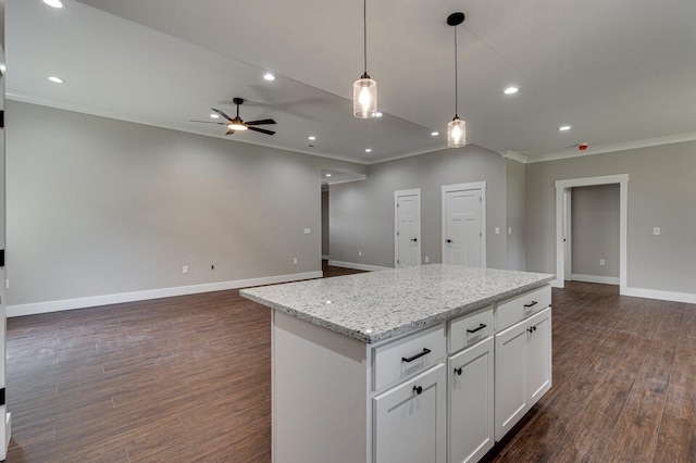 kitchen with crown molding, dark hardwood / wood-style flooring, ceiling fan, and white cabinets