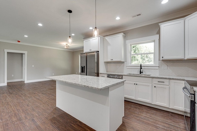 kitchen with a center island, sink, white cabinets, appliances with stainless steel finishes, and light stone countertops