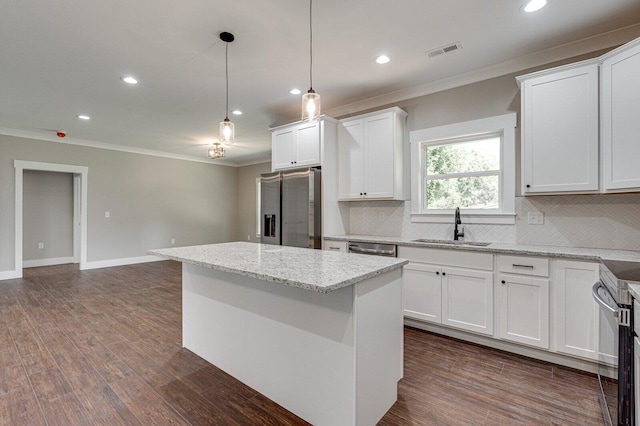 kitchen with visible vents, crown molding, tasteful backsplash, a sink, and stainless steel appliances