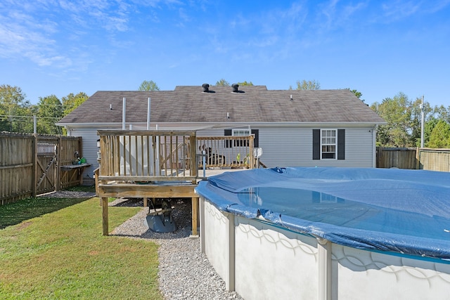 back of property with a lawn and a deck