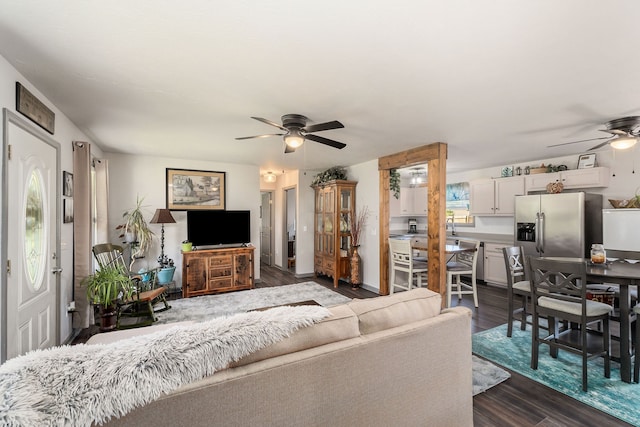 living room featuring ceiling fan and dark wood-type flooring