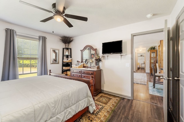 bedroom with a textured ceiling, dark hardwood / wood-style floors, and ceiling fan