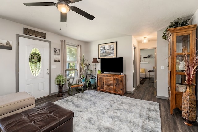 living room featuring ceiling fan and dark wood-type flooring