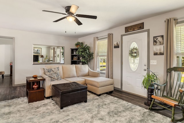 living room featuring ceiling fan, a healthy amount of sunlight, and dark hardwood / wood-style flooring