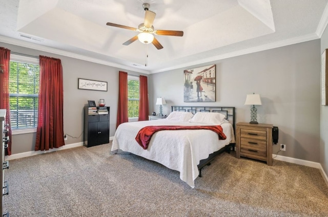 bedroom with a raised ceiling, ornamental molding, multiple windows, and ceiling fan