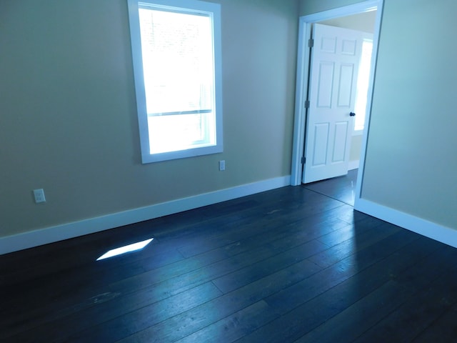 spare room featuring dark hardwood / wood-style floors and a healthy amount of sunlight