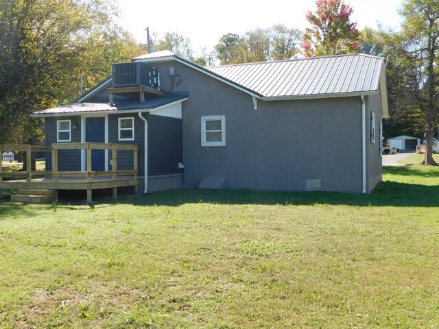 back of house with cooling unit, a lawn, and a wooden deck