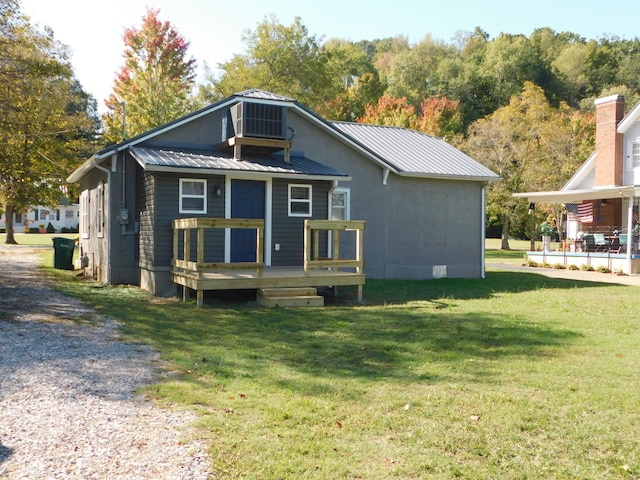 rear view of house with a yard and a wooden deck