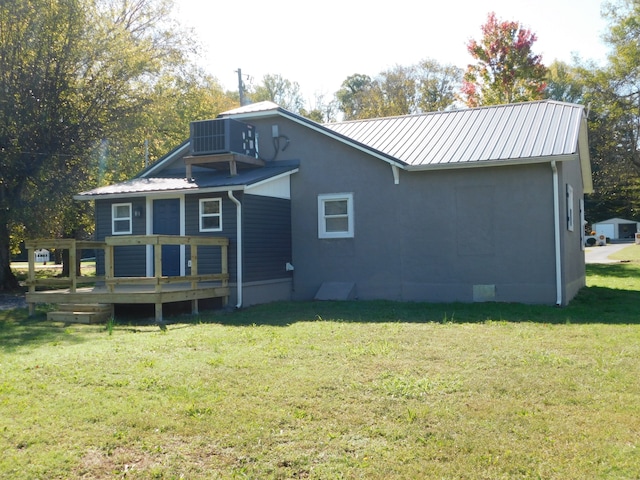 back of property with cooling unit, a wooden deck, and a yard