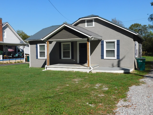 rear view of property featuring a lawn