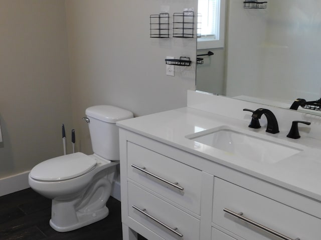 bathroom featuring vanity, hardwood / wood-style floors, and toilet