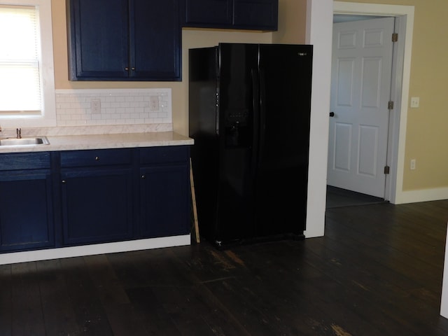 kitchen featuring blue cabinets, black fridge, and dark hardwood / wood-style flooring