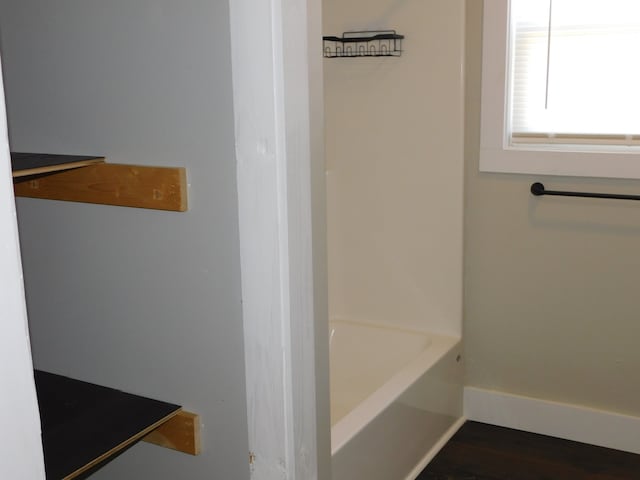 bathroom featuring wood-type flooring and plus walk in shower