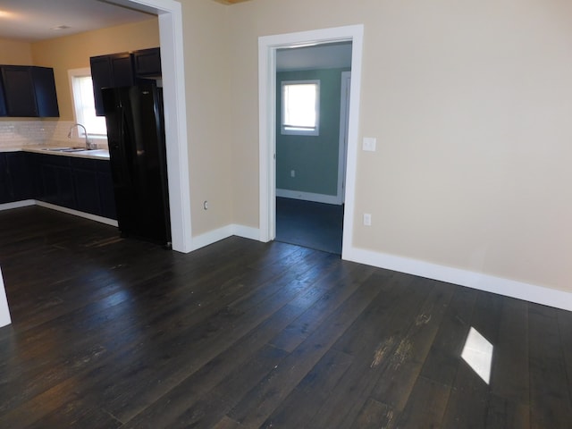 interior space featuring dark wood-type flooring, sink, and backsplash