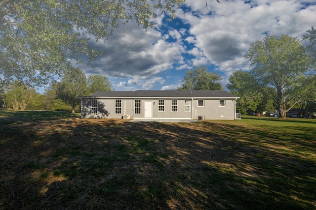 rear view of property featuring a lawn and a patio