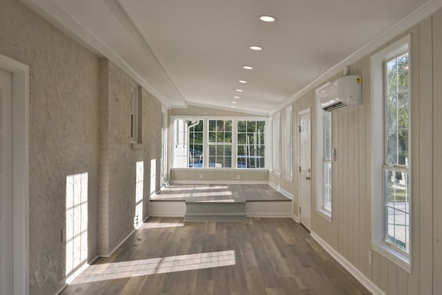 hall with a wall mounted air conditioner, dark wood-type flooring, vaulted ceiling, a wealth of natural light, and crown molding