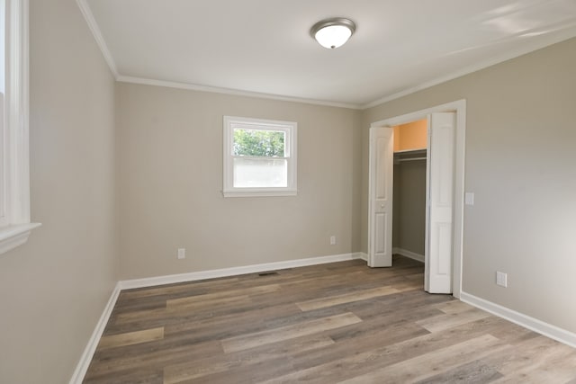 unfurnished bedroom featuring a closet, ornamental molding, and light hardwood / wood-style flooring