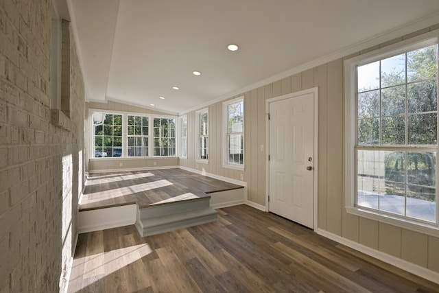 entryway with crown molding, a wealth of natural light, lofted ceiling, and dark hardwood / wood-style floors