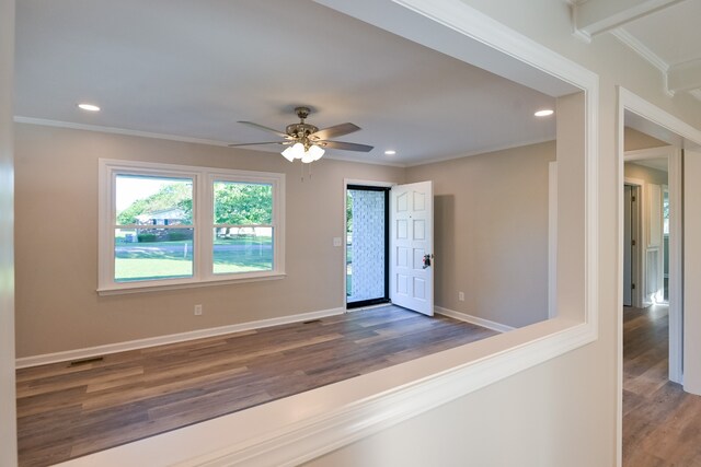 interior space with dark wood-type flooring, crown molding, and ceiling fan