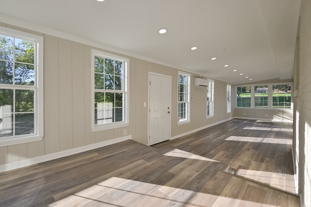 interior space with dark hardwood / wood-style flooring, crown molding, and a wall mounted air conditioner