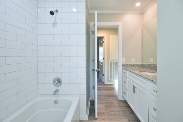 bathroom with vanity, tiled shower / bath, ornamental molding, and hardwood / wood-style flooring