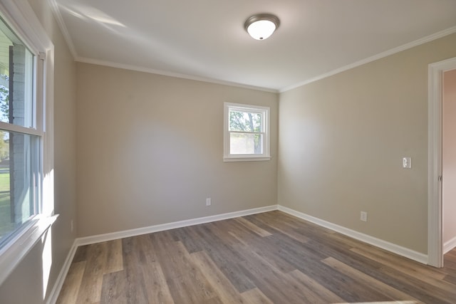 empty room with ornamental molding and hardwood / wood-style flooring