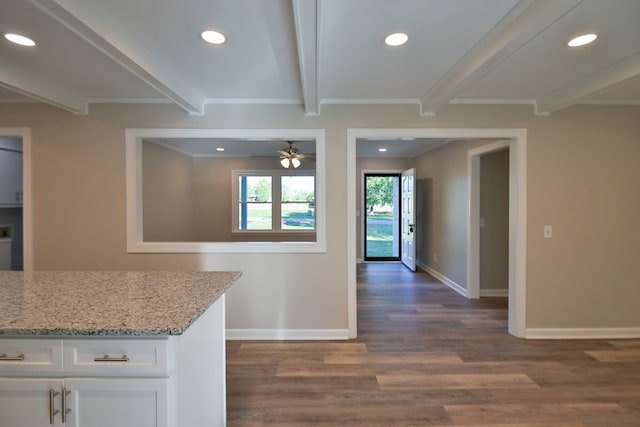 kitchen with ceiling fan, beam ceiling, light stone countertops, dark wood-type flooring, and white cabinets