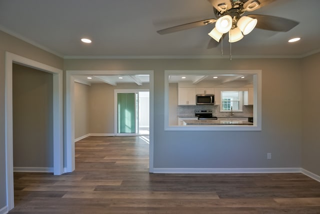 kitchen featuring backsplash, crown molding, dark wood-type flooring, stainless steel appliances, and white cabinets