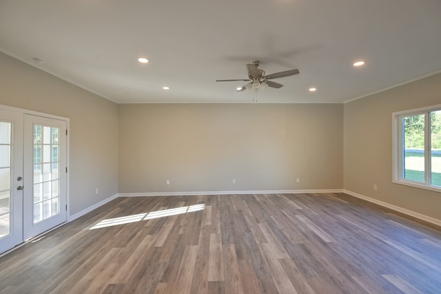 empty room featuring hardwood / wood-style flooring, ceiling fan, ornamental molding, and french doors