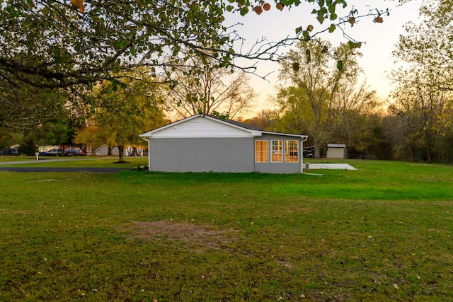 property exterior at dusk with a yard