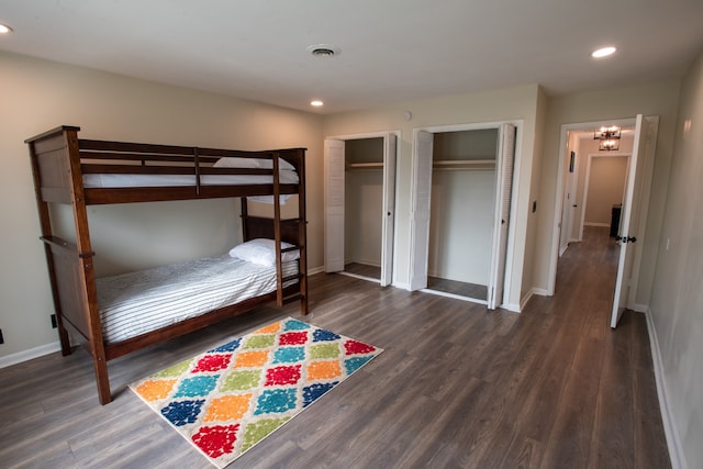 bedroom with two closets and dark hardwood / wood-style floors