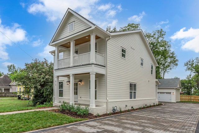 view of front of house featuring a balcony, a front lawn, covered porch, and a garage