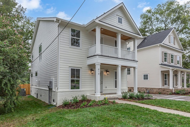 view of front of home featuring a balcony, a porch, a front lawn, and central AC