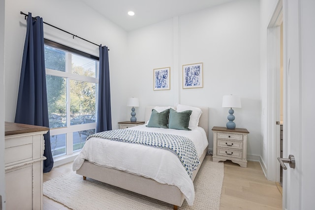 bedroom with light wood-type flooring and multiple windows