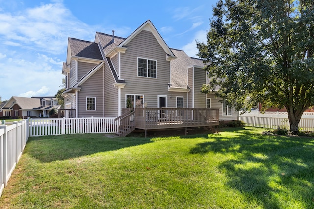 rear view of property with a wooden deck and a lawn