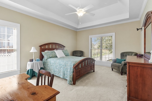 carpeted bedroom featuring crown molding, ceiling fan, and a raised ceiling