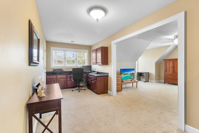 carpeted office space featuring ceiling fan and built in desk