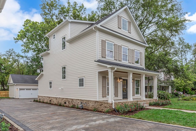 view of front of house with an outbuilding, covered porch, a front yard, and a garage