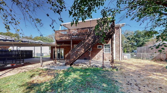 rear view of property featuring a patio area and a wooden deck