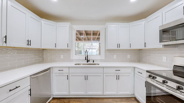 kitchen featuring white cabinets, appliances with stainless steel finishes, tasteful backsplash, and sink